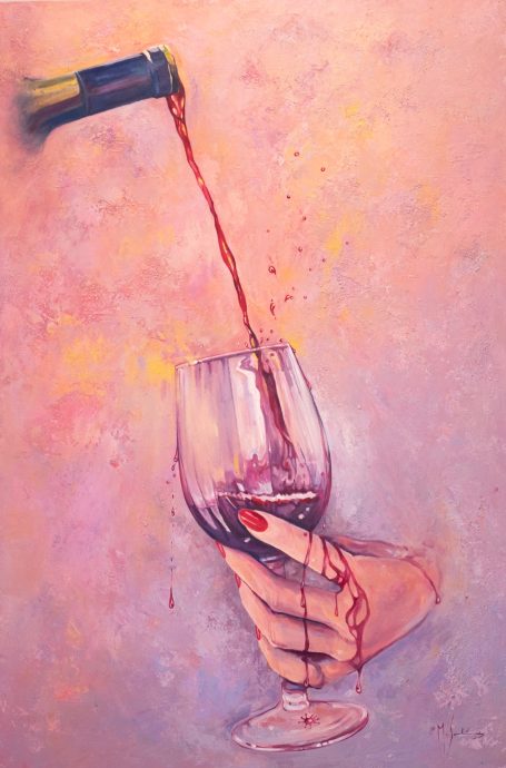 Vino tinto vertiéndose en una copa salpicando y cayendo por la mano.