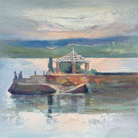 Pabellón en un muelle sobre aguas tranquilas al atardecer, rodeado de paisajes suaves.