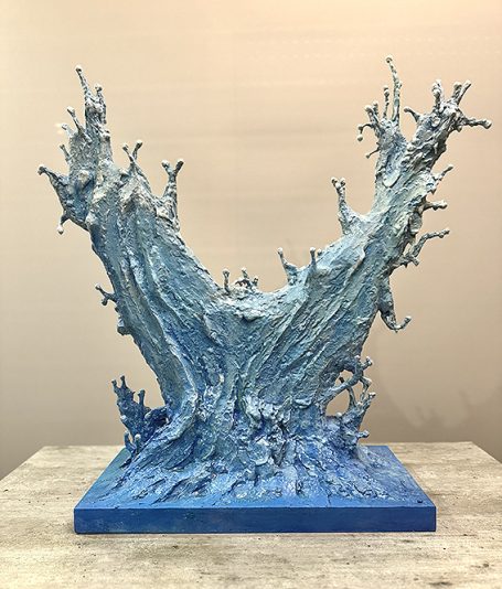 Escultura abstracta en tonos azules, con formas orgánicas y dinámicas.